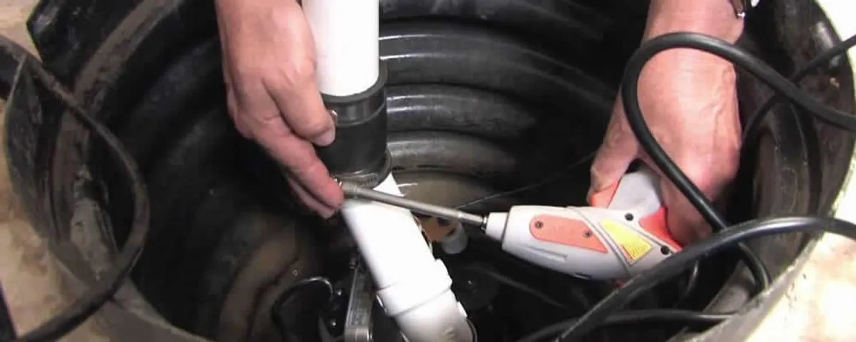 Sump pump installation technician connecting PVC discharge piping in San Jose, CA